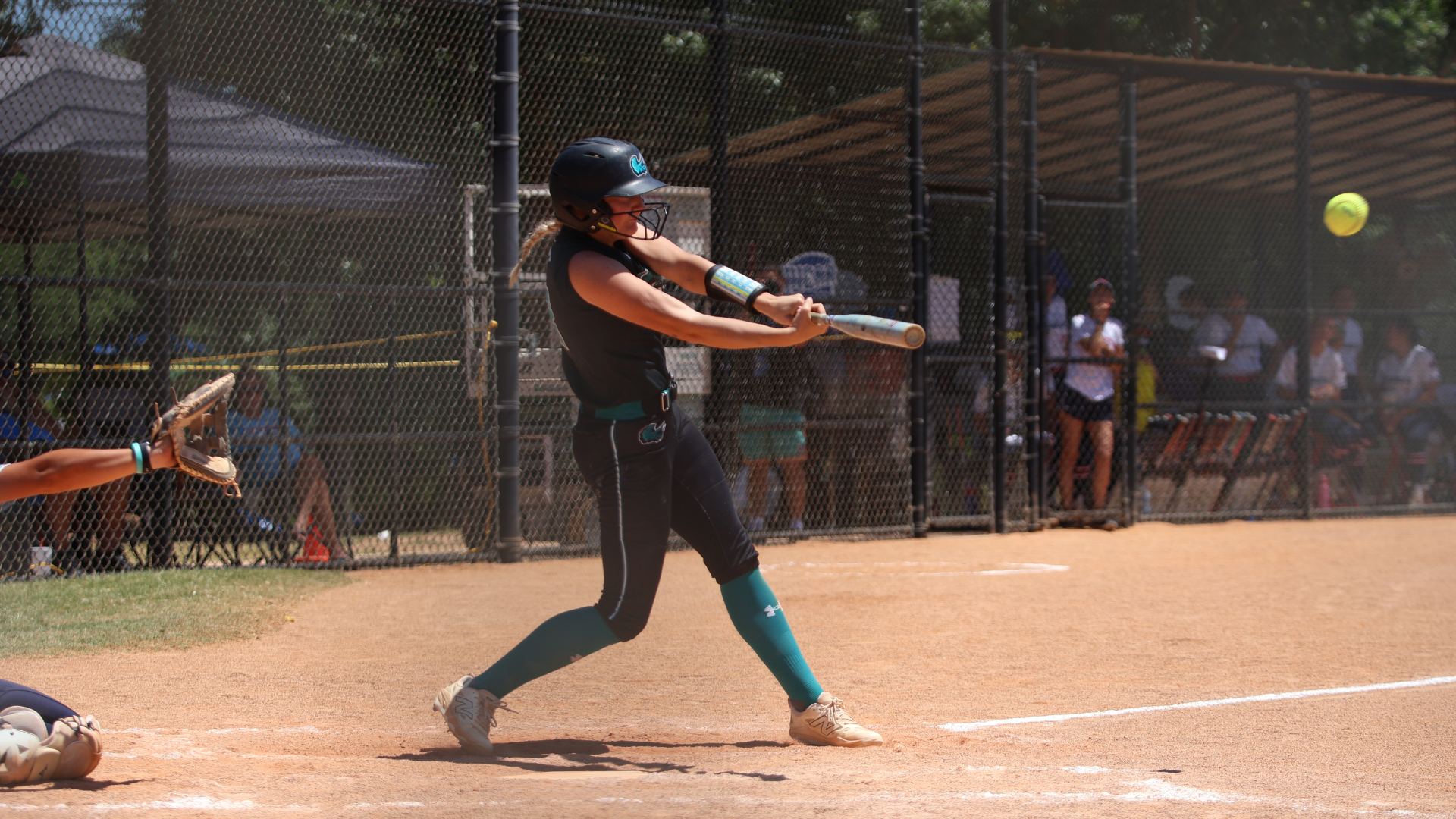 Softball player swinging at a pitch
